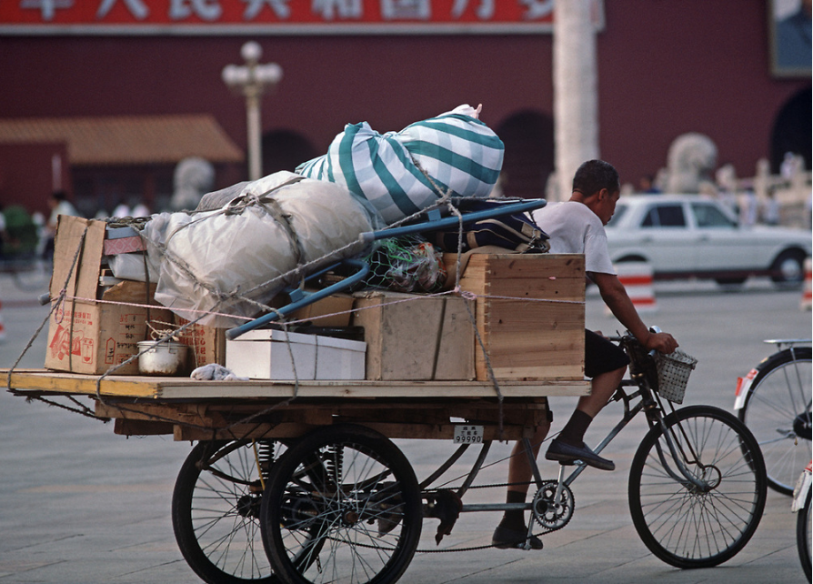 1985年，北京天安门前走过的三轮车。
