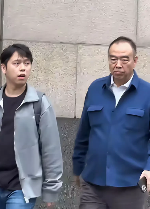 这张照片是网友在上海街头偶遇时拍摄的，画面中的两人是中国著名导演陈凯歌和他的长子