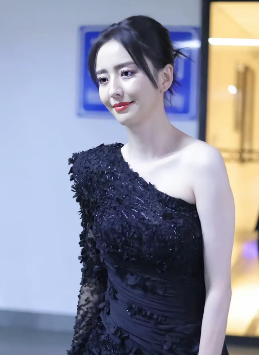 后台通道里佟丽娅被路人镜头抓个正着
黑色斜肩礼裙，碎钻和立体花片在灯光下闪着光，