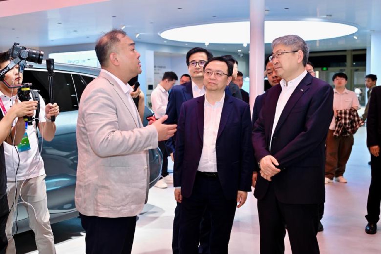 2026 年北京国际车展上，雷军到访比亚迪展馆并赠送定制 T 恤，印有 “在一起