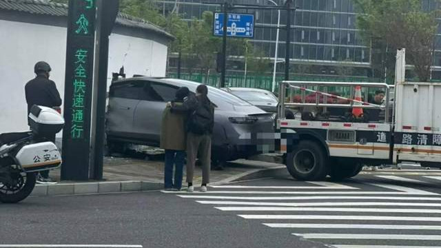 杭州街头这辆新能源车刚撞穿围墙，脱困瞬间就被车衣裹成“粽子”