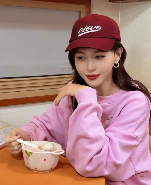 唐嫣在社交平台分享自己的美照
照片中的唐嫣头戴酒红色棒球帽，身穿粉色卫衣
长发披