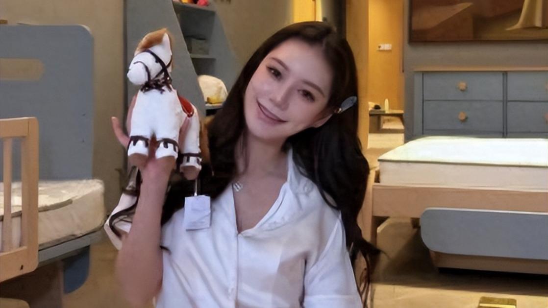 她穿着白色的裹胸上衣，孕肚的弧度很明显，脸以及胳膊和腿还是瘦的