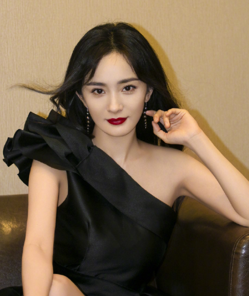 身穿黑色半肩礼服裙，脚踩细绑带高跟鞋