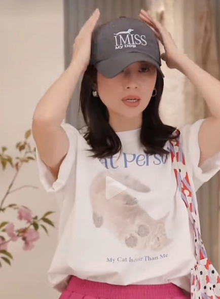 董洁身穿了一件带动物图案白色T恤，下面穿了一件粉红色的短裤，戴了一顶深灰色的棒球