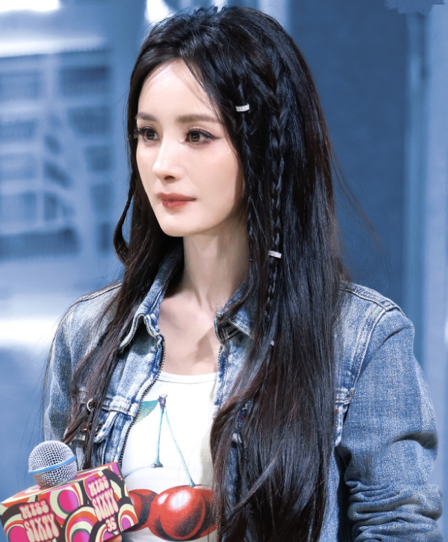 杨幂里面穿白色紧身T恤
下身搭配做旧风格的牛仔裤，让她秀出了苗条的细腰，还展现出