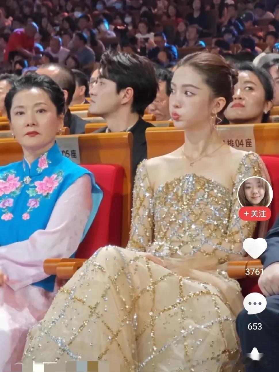 图片里何赛飞老师旁边的这个女人，有认识吗？ 她嘟起嘴巴，到底是在扮萌，还是在故意