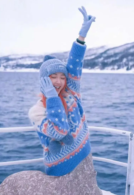 毛晓彤染橘粉长发雪地漫步元气个性 穿费尔岛毛衣活力又温柔