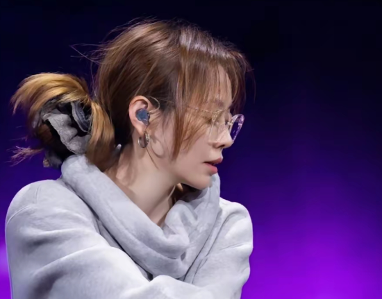 穿着oversize的灰色卫衣，下半身搭配了印有蝴蝶纹身的丝袜