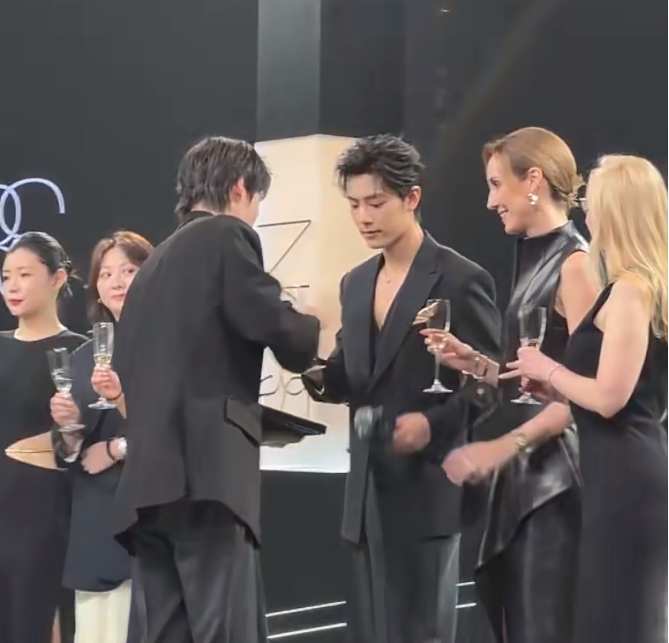 肖战左手边的两位女士离肖战比较近率先碰杯
这过程中右边隔着硕大粉底液的女士也走了