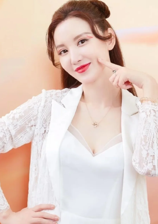 张萌身穿缎面吊带短裙
外搭黑色长开衫，用宽腰带勾勒出腰线，整个人又飒又媚
最吸睛