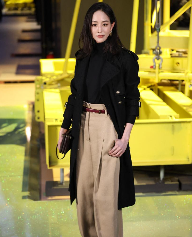 张钧甯里面穿黑色打底衫外面套着黑色的风衣看上去有种风度翩翩的感觉
她下身搭配米色