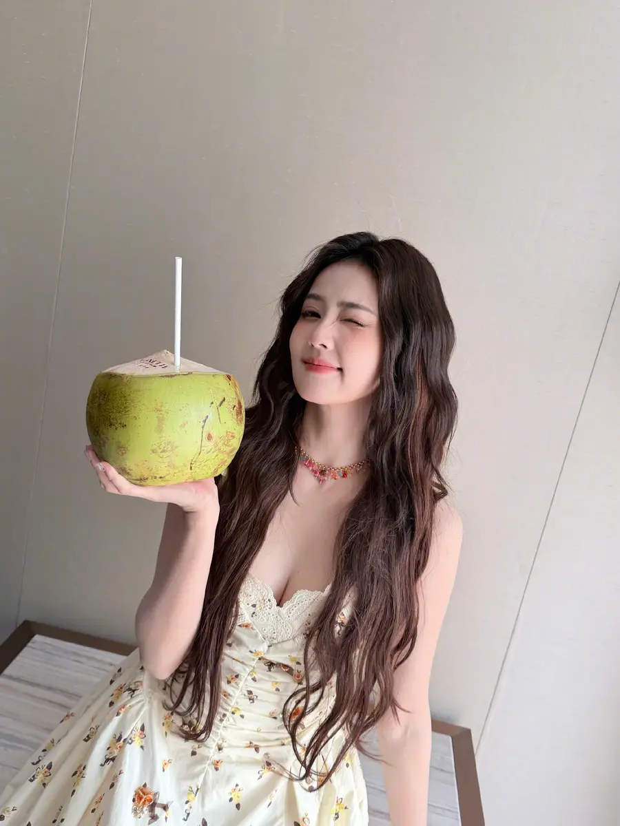 白鹿穿碎花吊带裙卷发温柔 捧椰子甜笑元气又活力