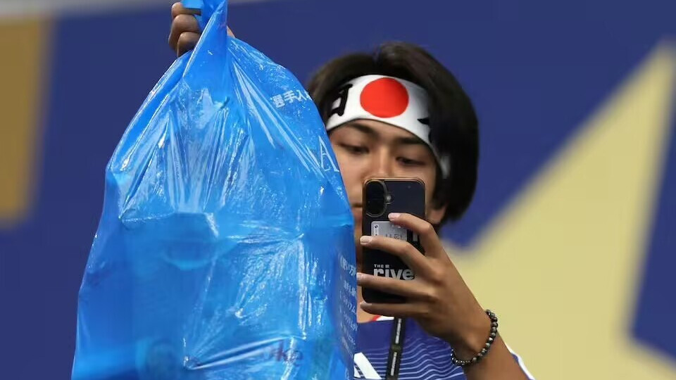 挥舞垃圾袋入场！日本球迷在世界杯捡垃圾被本国民众批“出国作秀”：一人拍摄、四人捡垃圾