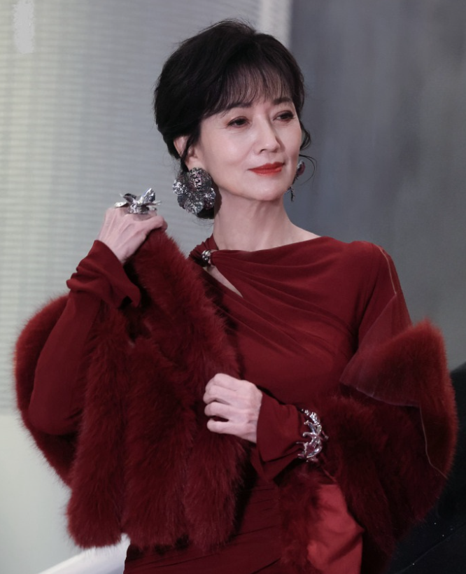 赵雅芝在出席活动的时候穿了一身大红色的衣服看上去特别的靓丽
她里面穿时尚的裙子，