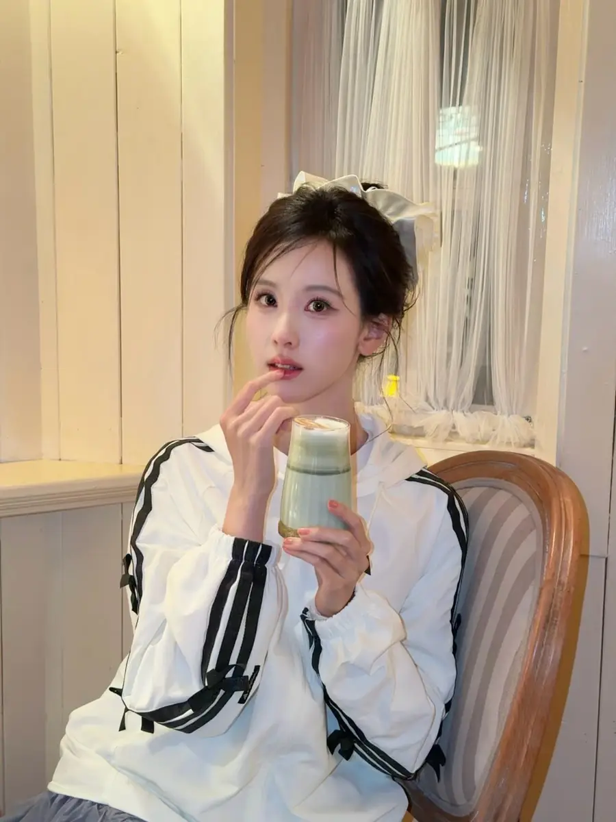 陈都灵手捧饮料明媚灵动，笑容浅浅清纯又大方