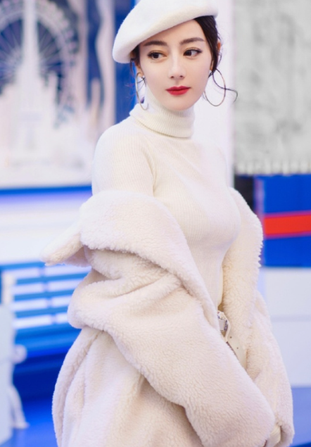 迪丽热巴白色为主色调的穿搭尽显温柔气质，上身是简约高领白毛衣，柔软质地尽显“奶呼