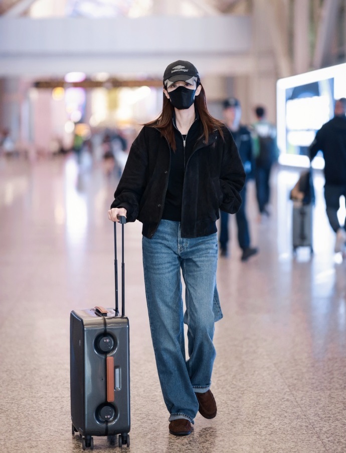 张小斐里面穿黑色针织衫，外面套装黑色绒面外套，两件衣服叠穿起来效果很不错