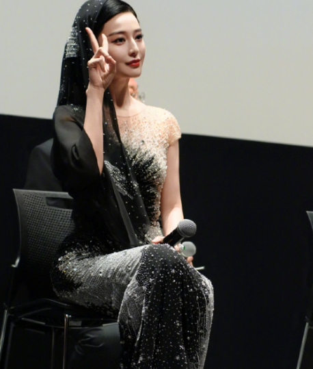 她身着一袭修身礼服，整体以渐变色彩呈现，自上而下的色调过渡自然且富有层次感