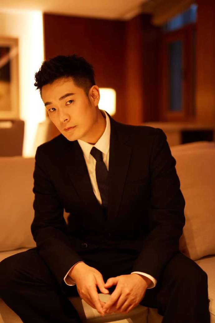 陈赫一身黑色西装简约大气，彰显成熟质感，展臂斜靠沙发，惬意自在