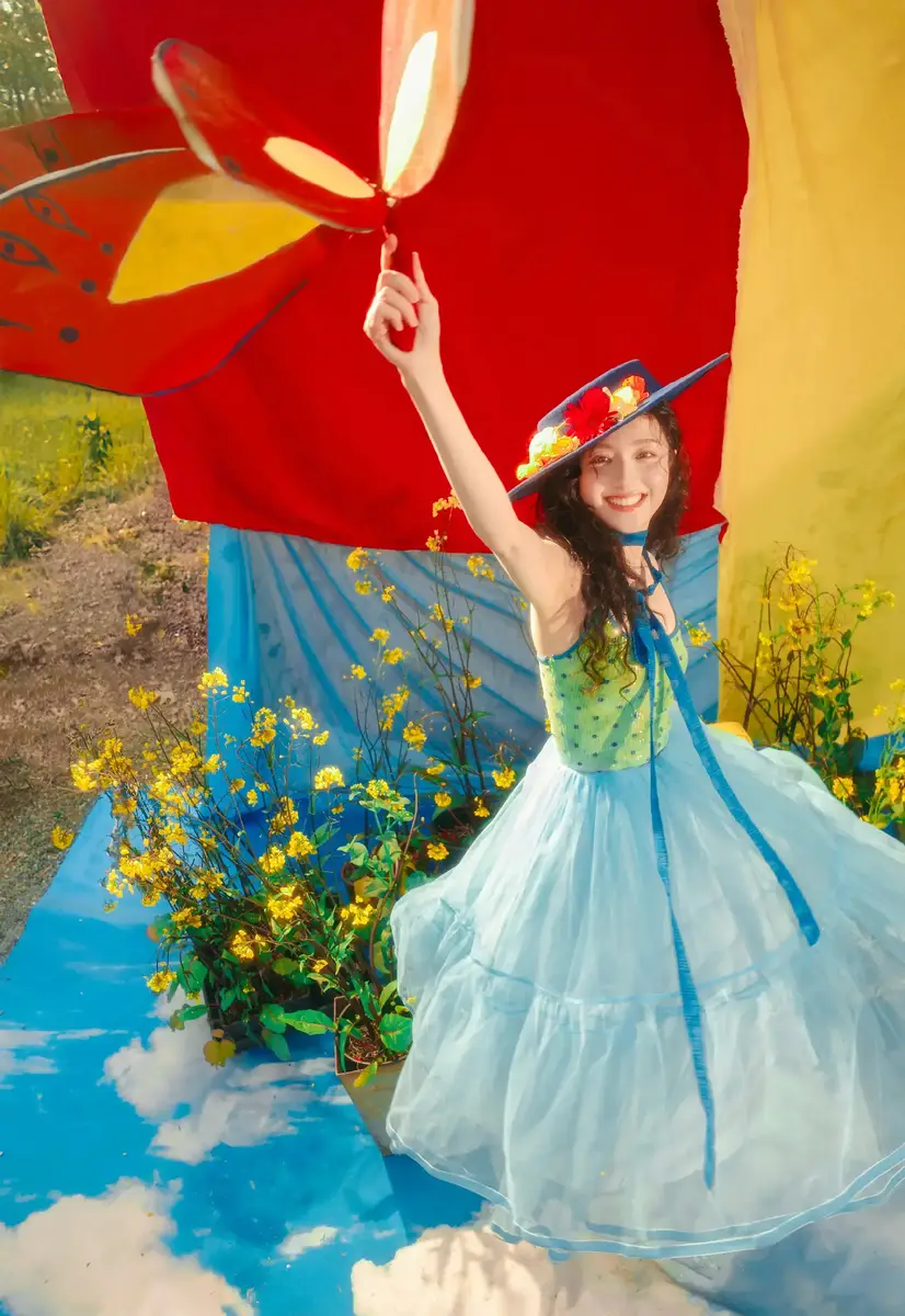 李兰迪穿蓝纱裙戴礼帽烂漫童趣 置身花海裙摆飞扬尽显春日活力