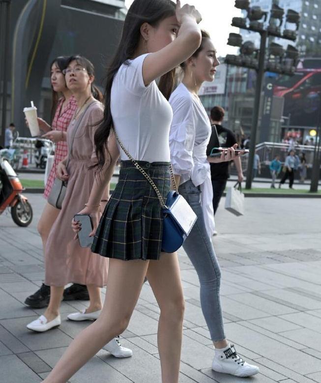 黑色格子短裙街头拍摄，腿型很是迷人