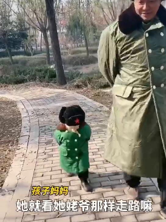  . 2岁萌娃穿军大衣模仿姥爷走路 姿势神态学得惟妙惟肖