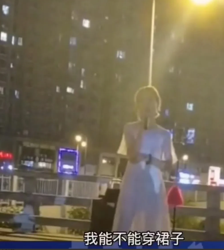 山西太原,一名男子居然穿着一件白色连衣裙,在居民区旁边的天桥上直播