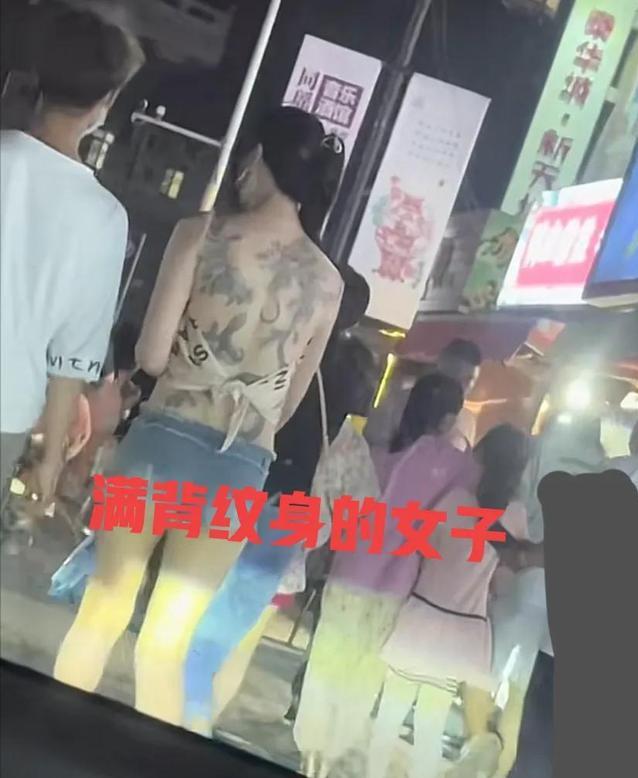 纪实：女子穿着一块布逛夜市，露出满背纹身惹争议，男友贴心搂腰