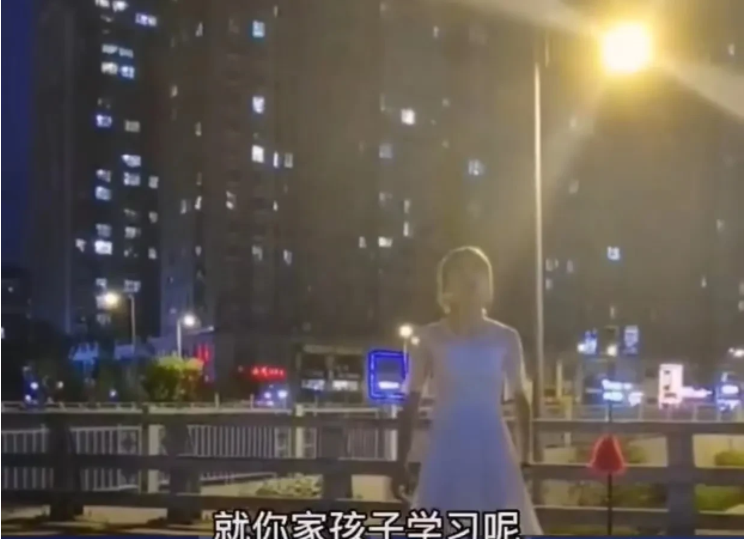 山西太原,一名男子居然穿着一件白色连衣裙,在居民区旁边的天桥上直播