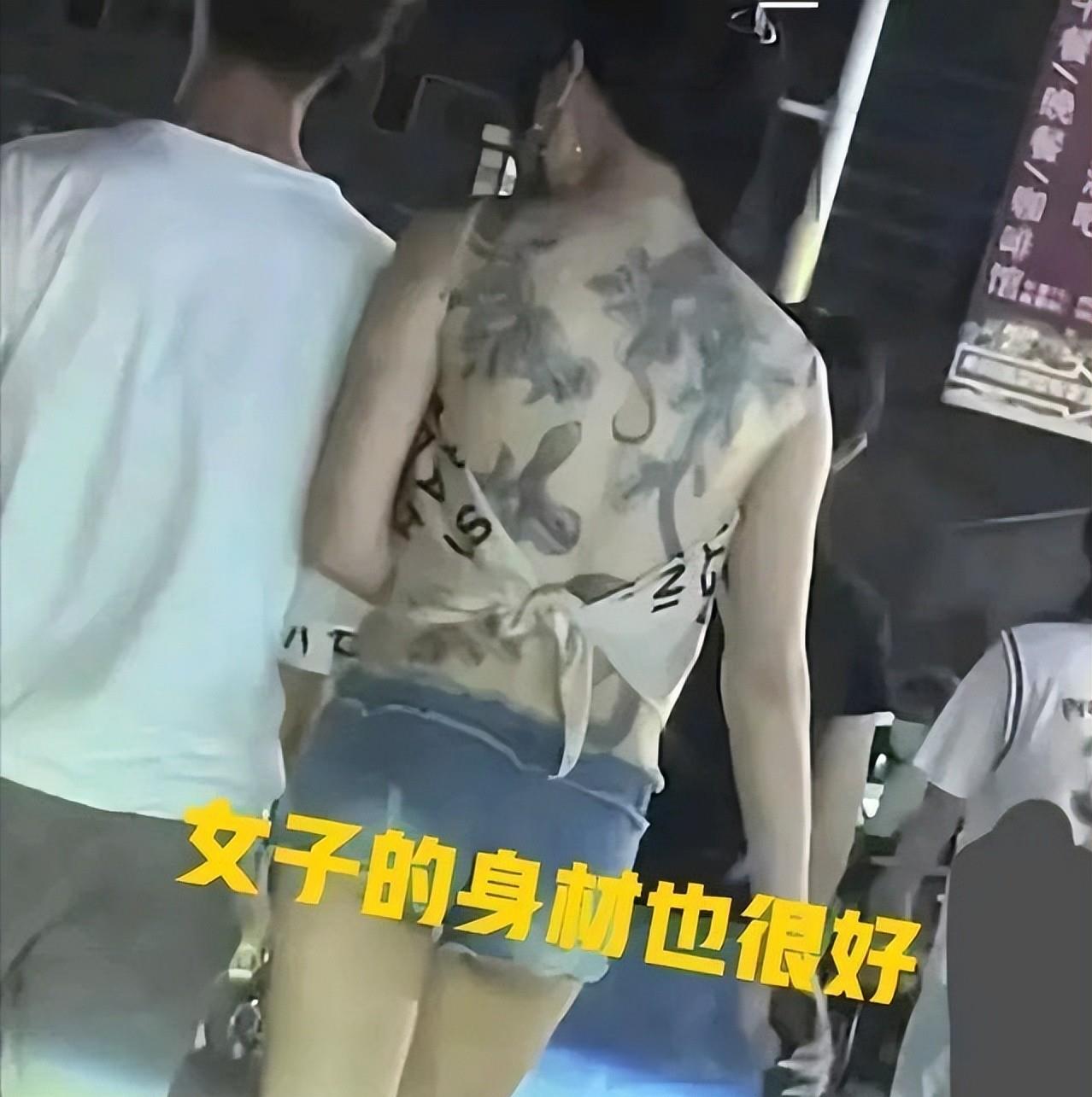 纪实：女子穿着一块布逛夜市，露出满背纹身惹争议，男友贴心搂腰