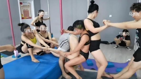 男孩练钢管舞总是偷懒，五名女子合力将其抓住，用腿夹头强制训练