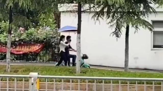 雨中，一女子奔跑着为骑车的男朋友打伞，网友：不懂珍惜