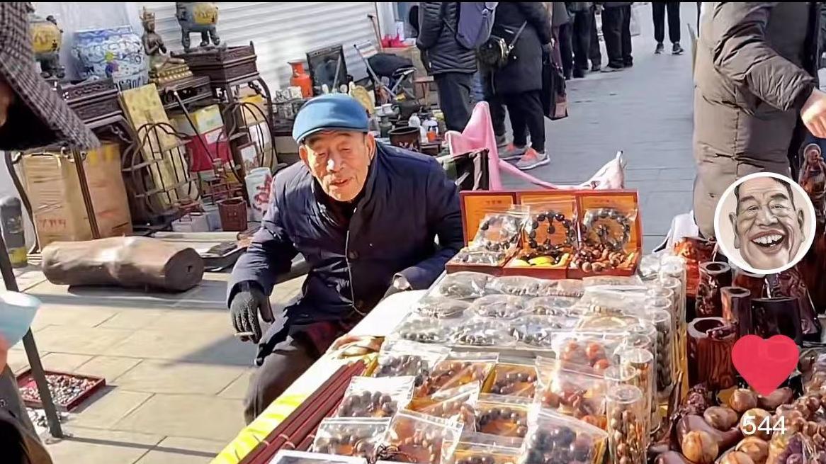 90岁杨少华在天津街头摆摊，坐轮椅穿厚袄清点货物，引众人围观