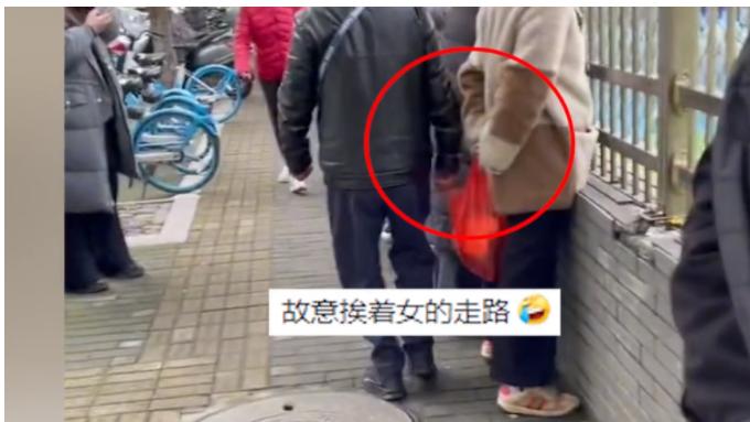 浙江，一女子站在学校围栏外，等着孩子放学，突然，手被人碰了下