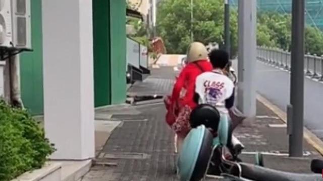 江苏一男孩坐后座抱手机打游戏，妈妈用力推车前行，路人直呼离谱