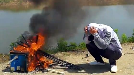 |男子为戒钓鱼瘾，直接蹲在岸边烧掉全部渔具，网友：出不了坑啦