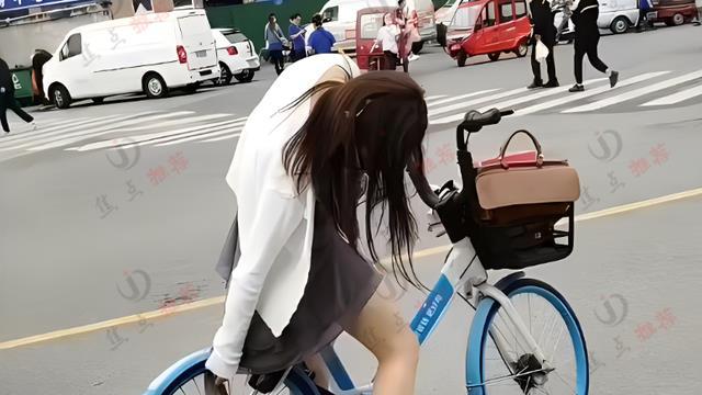 女子骑单车裙子卡住链条，旁边一群人排队却无人帮忙，让人心酸