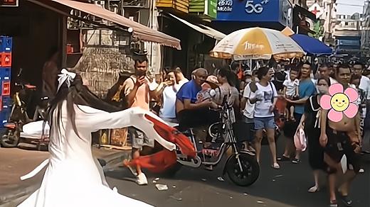 女子疯疯癫癫在街头唱白狐，转起圈来没完没了，白发大爷目不转睛
