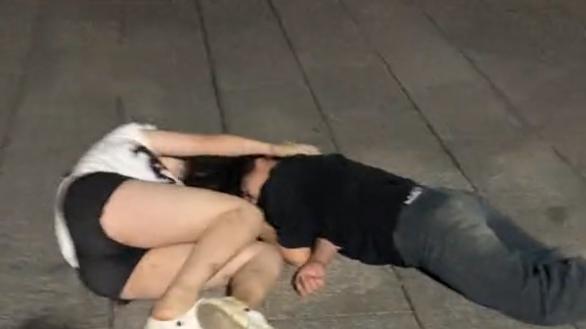 俩女子深夜醉倒街头，闺蜜好友站一旁大笑拍照，任由二人失态走光