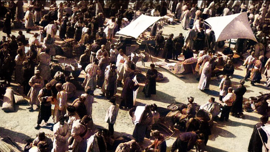 1934年的甘肃东乡：年轻女子挑担子汲水，男人屋顶上聊天晒太阳