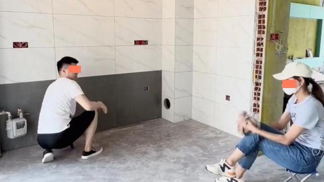 丈夫在装修房子，妻子在一旁指指点点，丈夫忍无可忍拉她去擦瓷砖