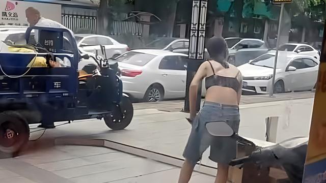 收废品的老板娘轻装上阵，背上的文身引人注目，年轻时也轻狂过