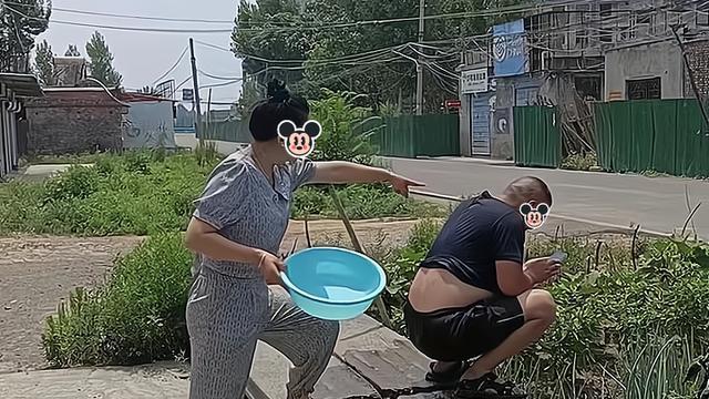 一女子让丈夫浇地，他却只顾玩手机，女子将水管插到他的裤子里