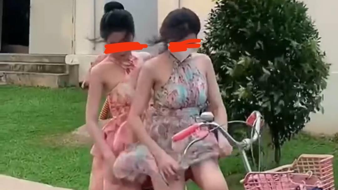 两名女子穿飘逸短裙骑自行车出行，遭遇大风天气裙角飞扬