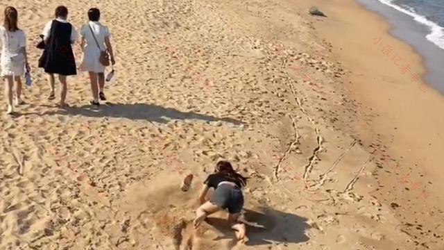 一女子跟相亲对象比赛跑步，没想到脚下一滑，整个人跪倒在沙滩上