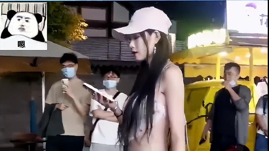 女子穿着清凉出门逛街，热裤下纹身可见，引路旁十余名男子拍照