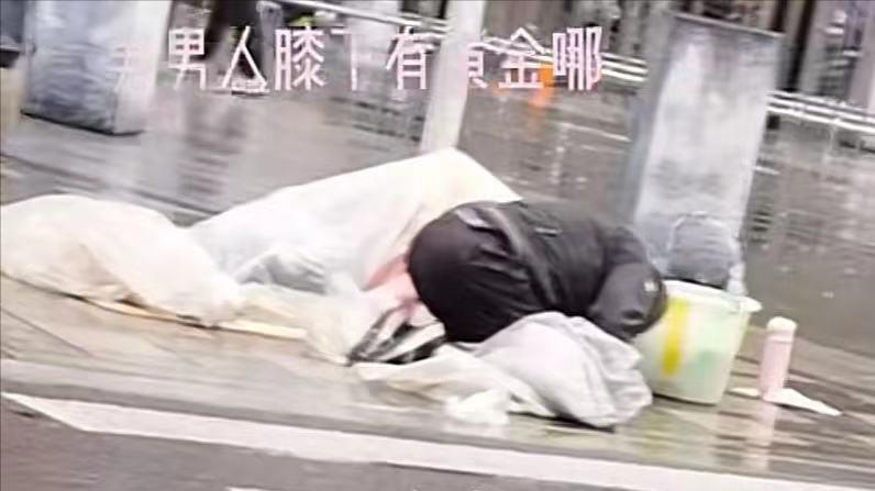 上海：大爷雨天在路边磕头乞讨，旁边躺着妻子，路人习以为常