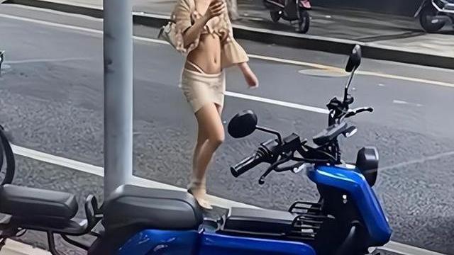 案例女子穿着清凉细绳缠腰，不在意路人拍照，对镜头面带微笑抛媚眼