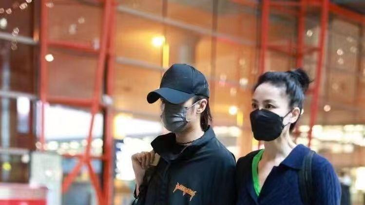 王菲 王菲牵谢霆锋走机场，扎马尾像高中生，小男友单手插兜扮酷